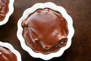 Homemade Chocolate Pudding in a white dessert dish sitting on a brown table