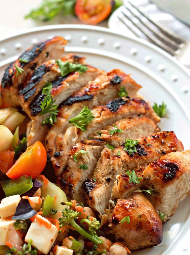 Mustard Chicken Marinade sitting on a white plate with roasted vegetables