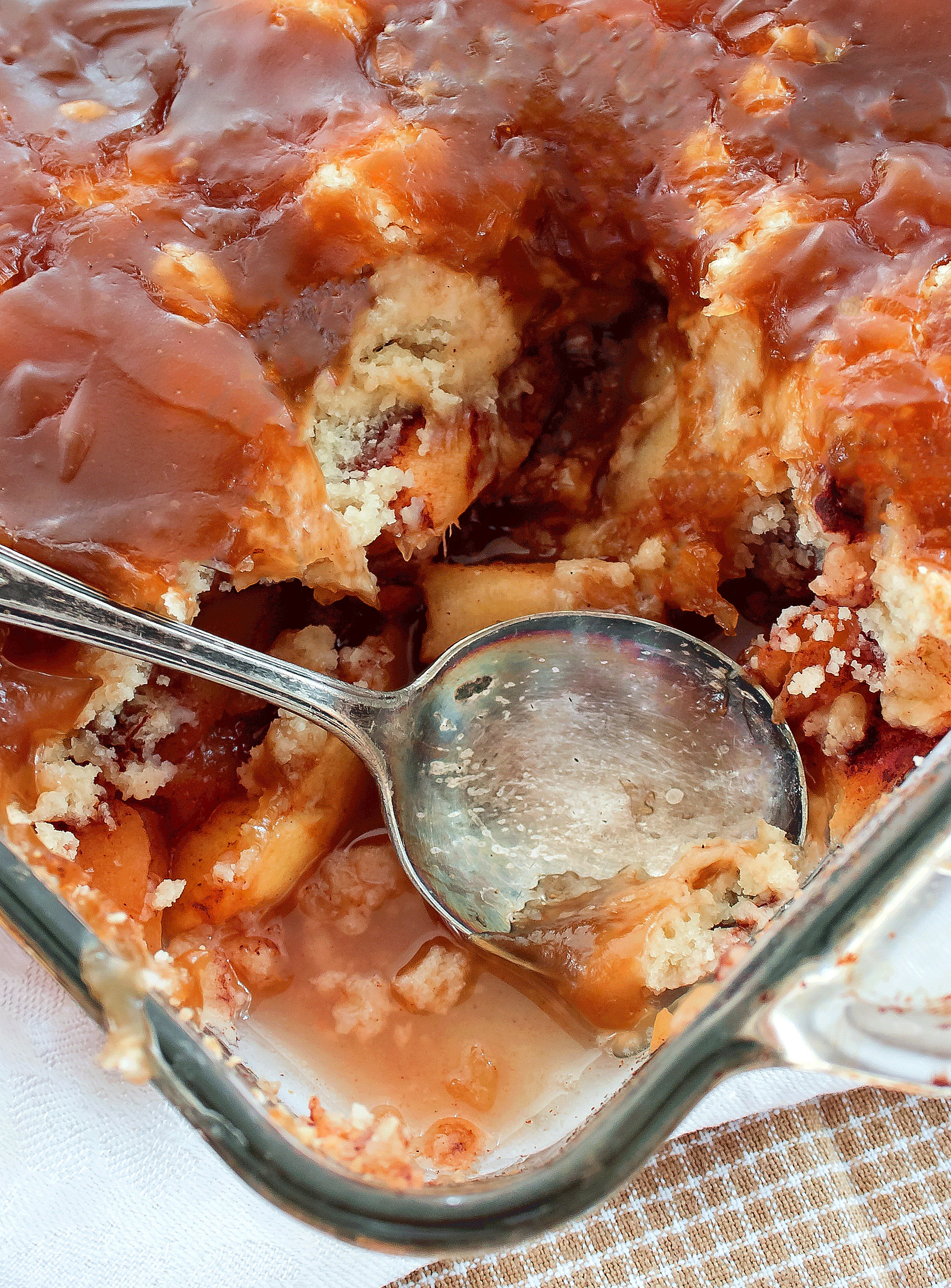  A picture of an Apple Pan Dowdy with a spoon in the center where a piece has been served