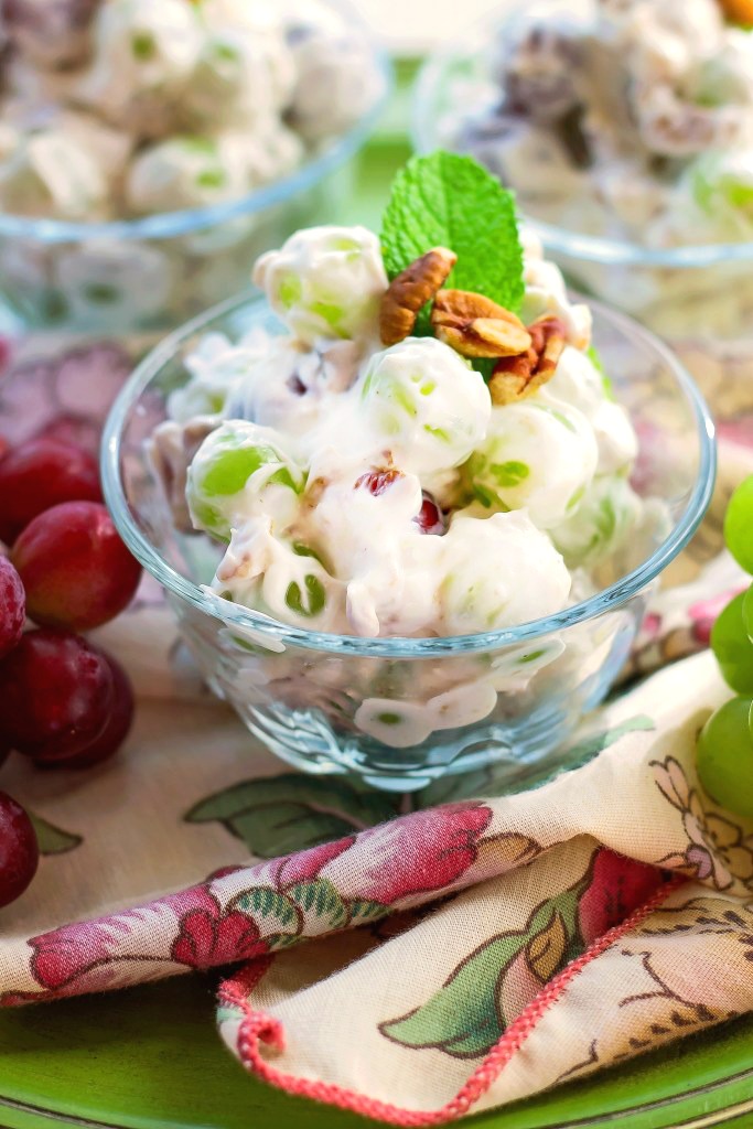 Grapes smoothers in a creamy sauce topped with pecans in a dessert cup