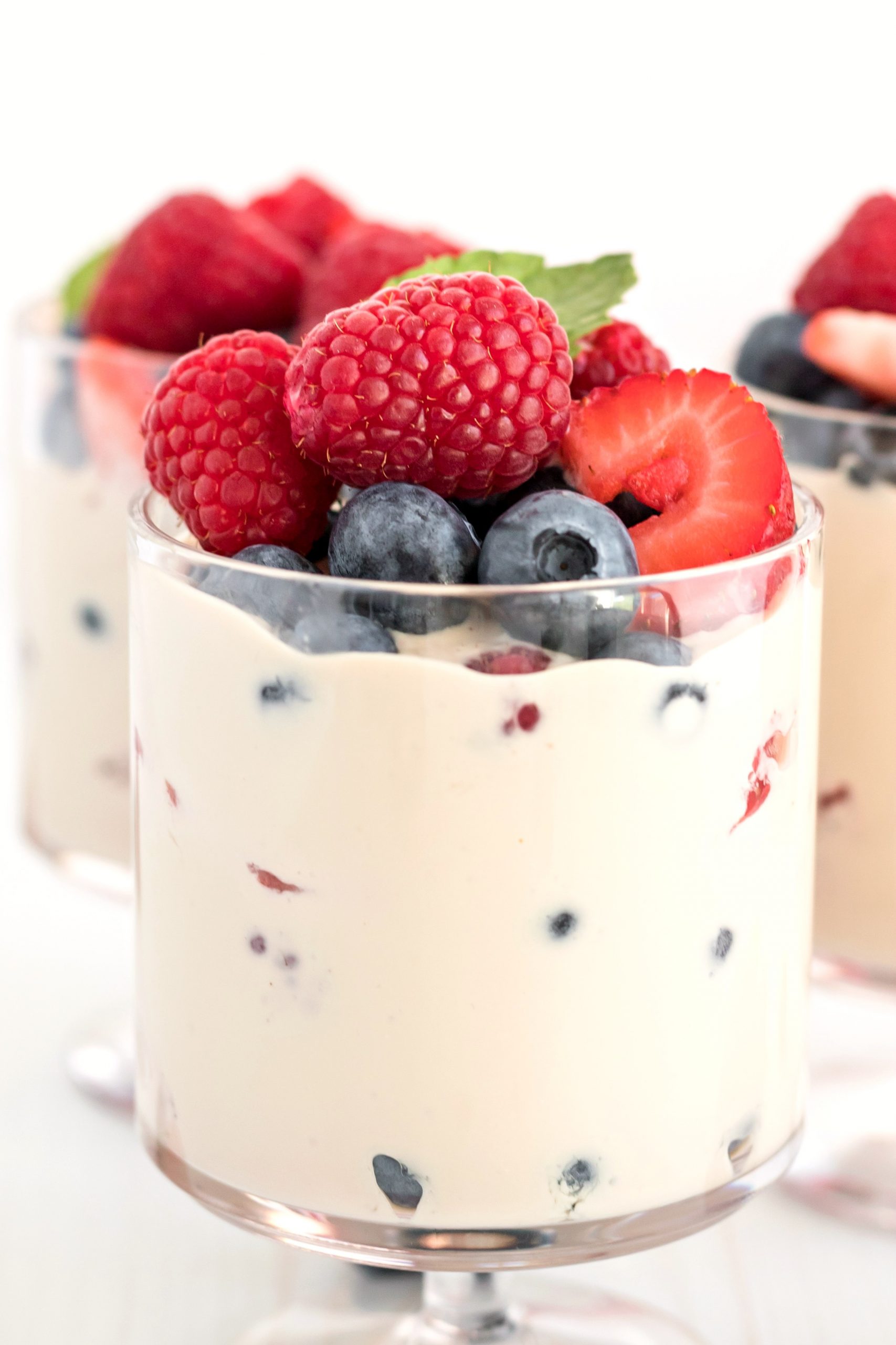 Assorted berries folded in and atop of a creamy mixture in a dessert cup